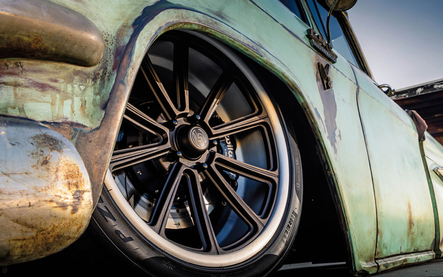 close up of a rim and a tire on a rusted blue '57 GMC