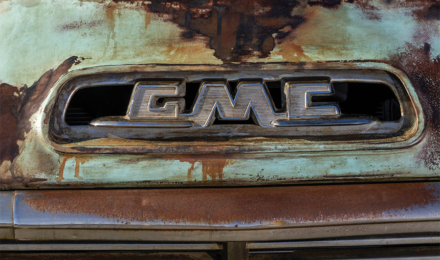 emblem on the front of a rusted blue '57 GMC