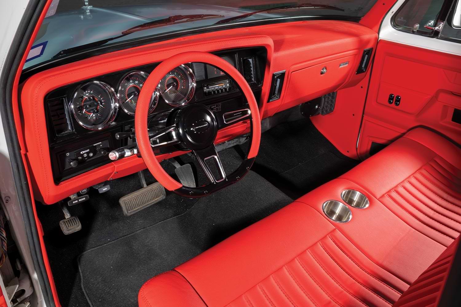 driver's side interior view of the ’89 Dodge Ram D150 featuring vibrant red leather seating and lining