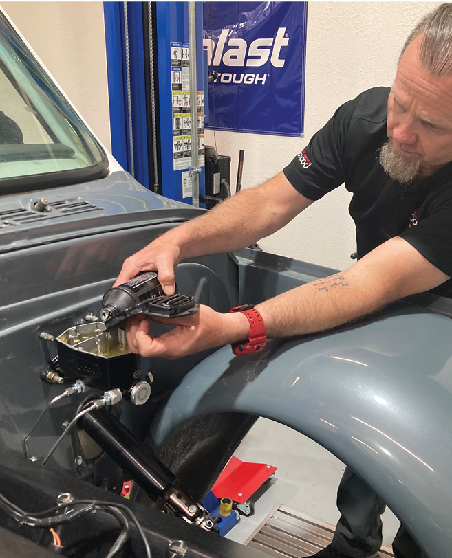 Mike Hamrick adds Wilwood brake fluid to the master cylinder in preparation to the final step, bleeding the system.