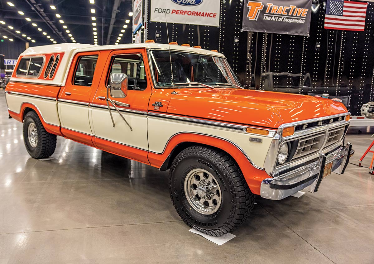 Close-up photograph perspective of a orange/tan shiny vintage Ford F-250 Ranger XLT truck on display inside the 2023 Grand National F-100 Show in Pigeon Forge, Tennessee