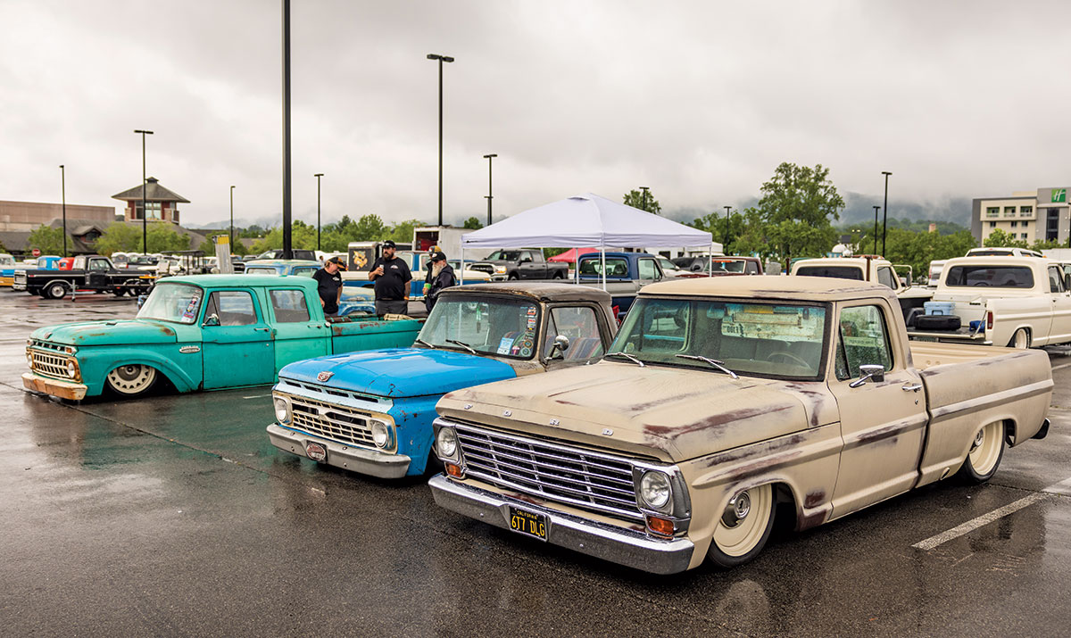 Aqua marine blue, baby blue, and tan colored vintage Ford F-100 cars are parked next to each other at the 2023 Grand National F-100 Show in Pigeon Forge, Tennessee on a gloomy day