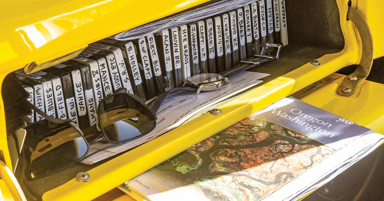 the ’56 Ford F-100 glove box containing many labeled casette tapes, sunglasses, and men's watch, registration papers and an Oregon Washington map