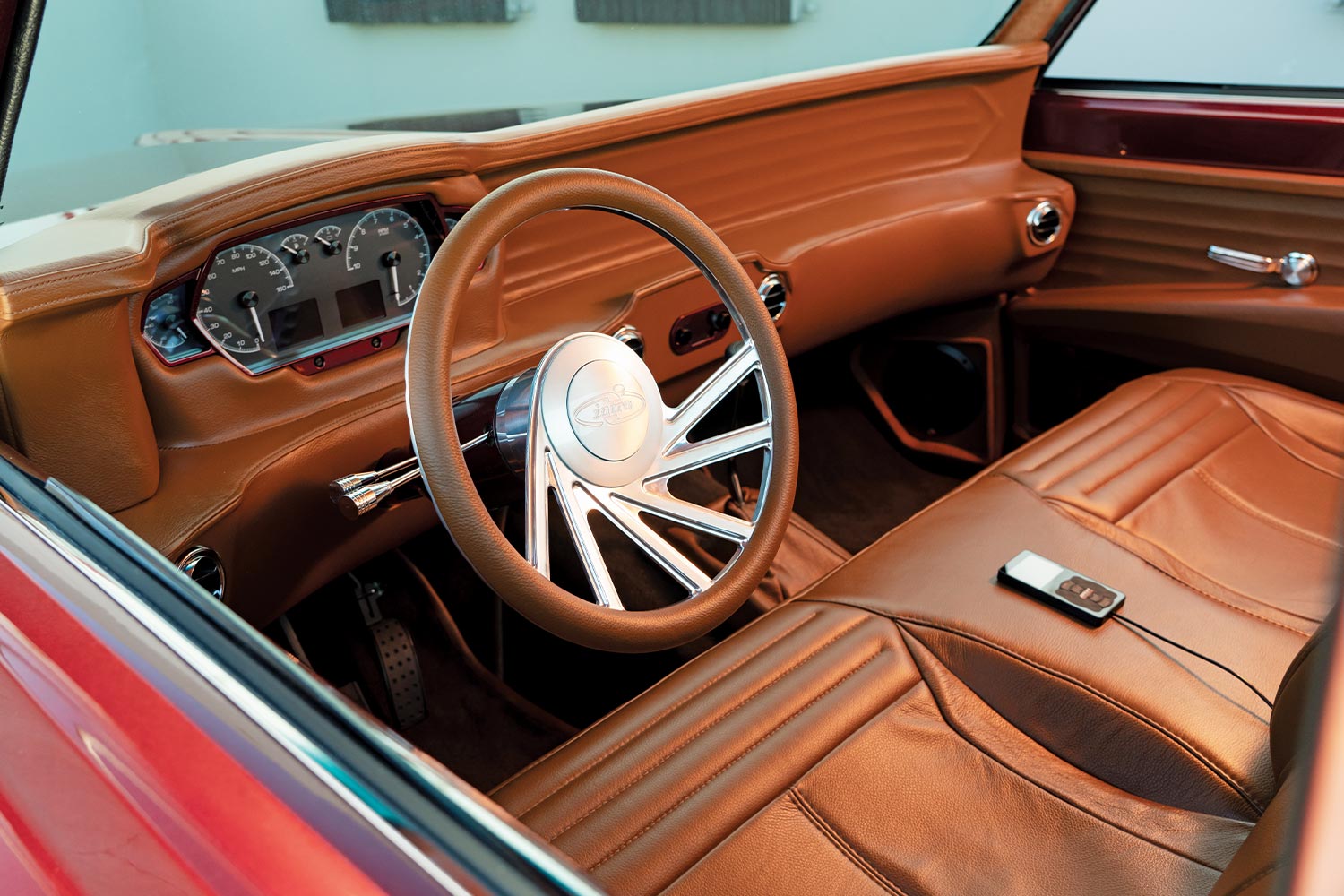 view from outside the driver side opened window of the ’68 Chevy C10, featuring the brown leather covered dashboard, steering and seating