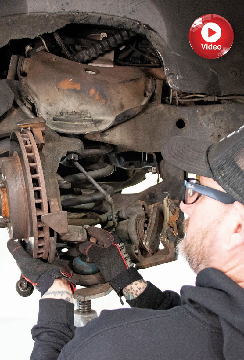 Mechanic working on OBS front suspension assembly