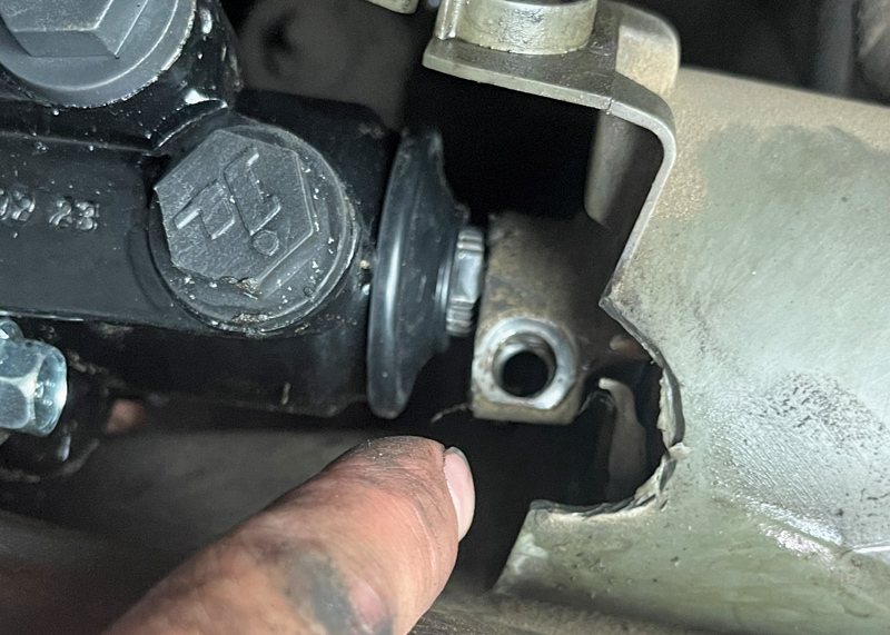 With the box mounted, we connected the steering rag joint to the shaft by sliding it into position. There’s a relief on the shaft that allows the bolt to go through to help secure the connection. Once aligned, tighten the bolt.