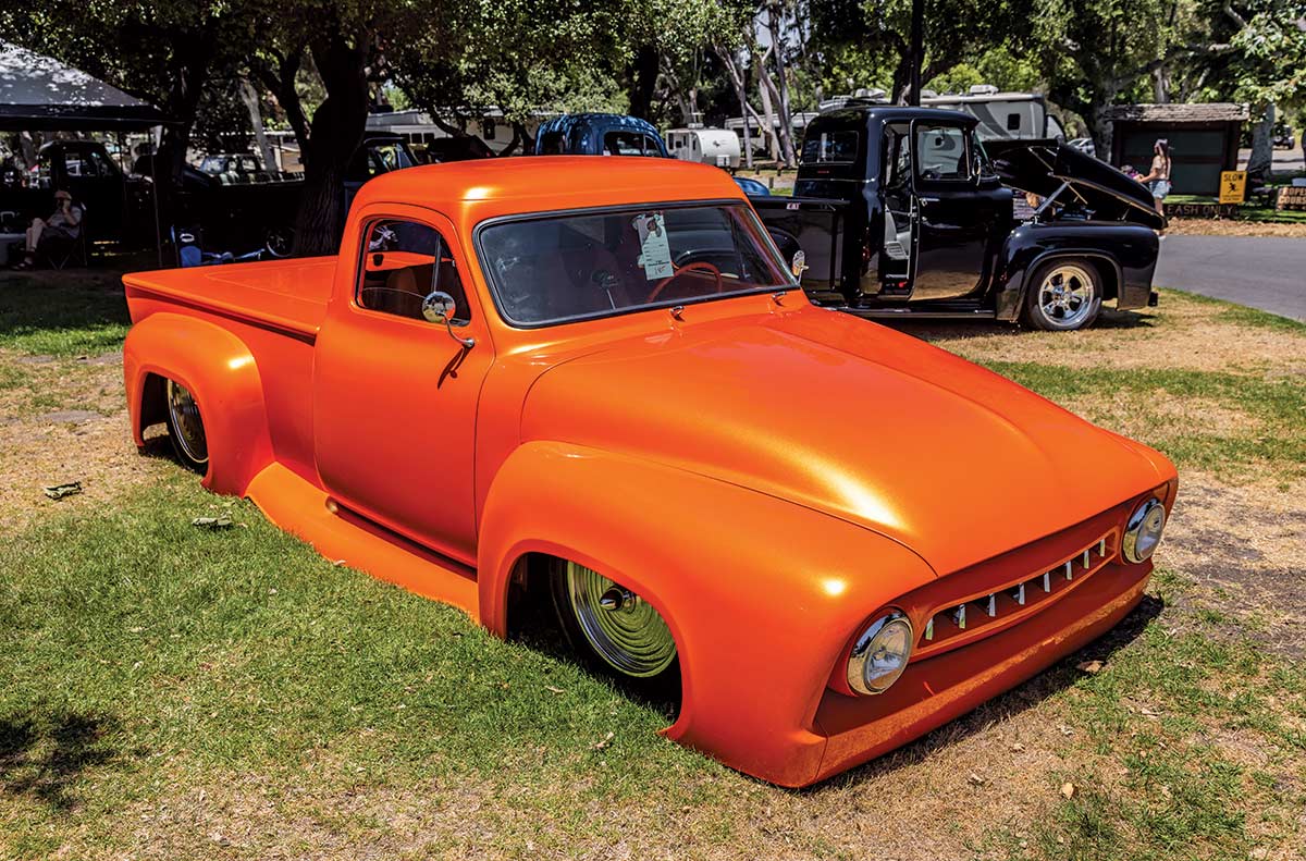 Landscape close-up photograph perspective of a orange vintage Ford vehicle parked on the grass at Canyon RV Park in Anaheim, California