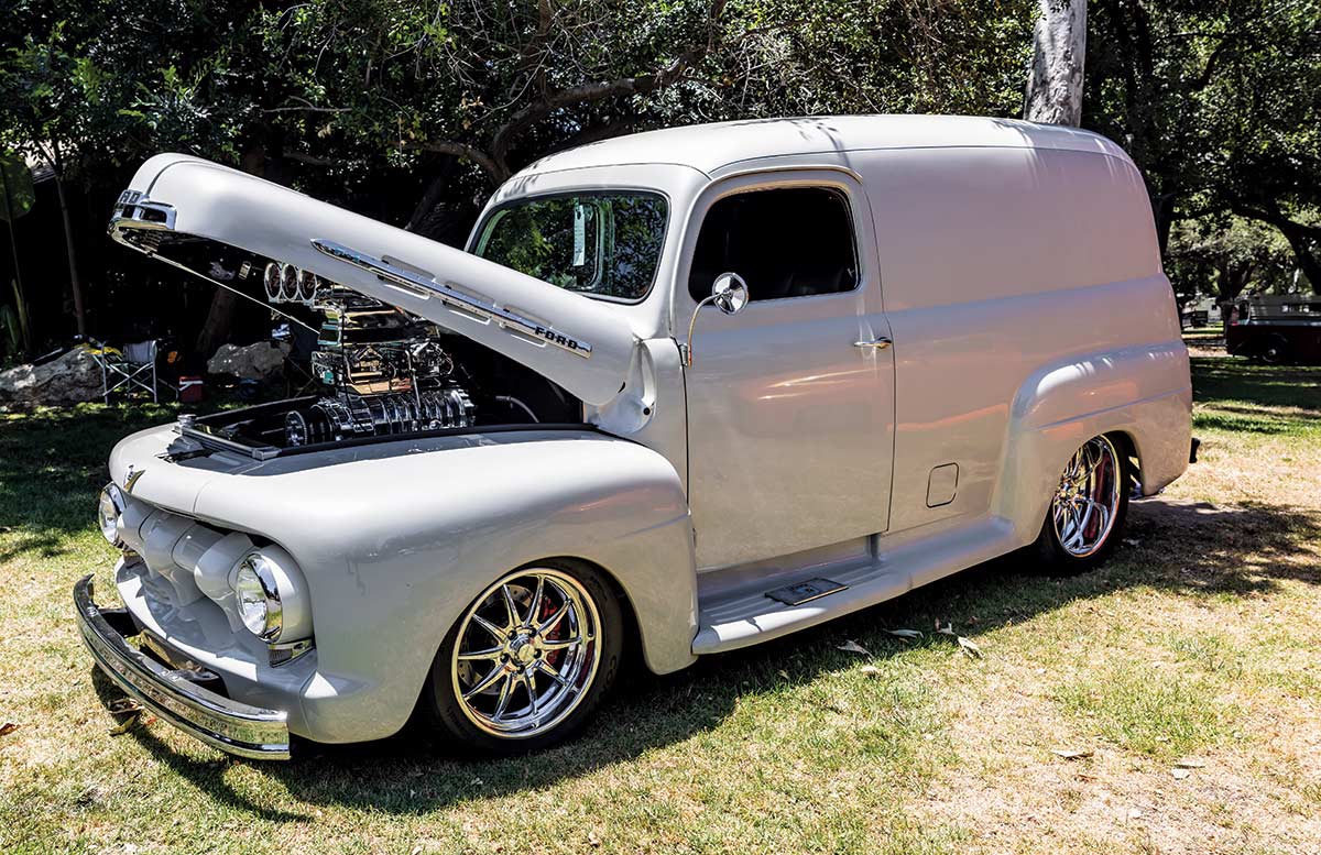 Landscape close-up photograph perspective of a grey Ford vintage vehicle with its hood open parked on display on the grass at Canyon RV Park in Anaheim, California
