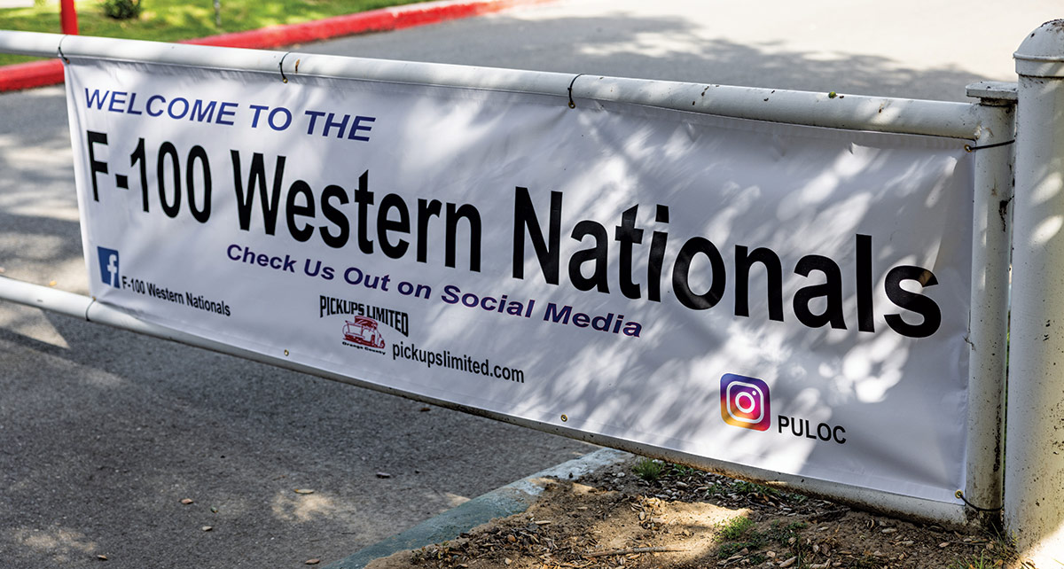 Landscape close-up photograph perspective of a white gate door banner that reads "Welcome to the F-100 Western Nationals: Check Us Out on Social Media" at Canyon RV Park in Anaheim, California