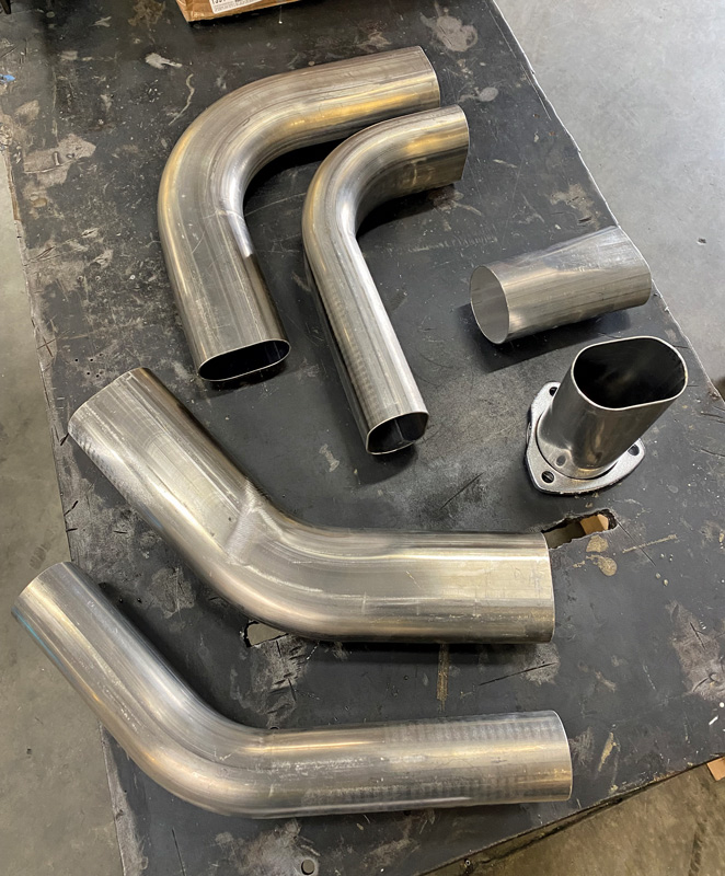 When working with oval tubing, bends exist on two different planes, horizontal and vertical, so close attention must be made as the initial materials list is created. The upper left 90-degree mandrel bend is bent in the horizontal plane, while the bend next to it is considered a vertical bend. A pair of 45-degree bends at lower left illustrates the same.