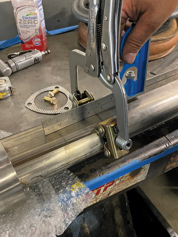 A flat, metal workbench makes for a great surface to weld tubing together, combined with a couple clamps. A straightedge is used to ensure the two sections of tubing are parallel and straight.