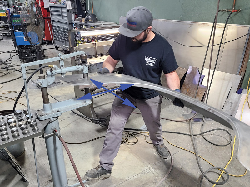 After slightly bending the panel over his knee to get the shape started, Gerringer then runs the part through the planishing hammer in an East-West then North-South direction, but it also helps flatten the welds.