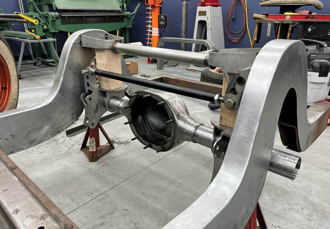 The rear axle crossmember is carefully positioned and tack welded into place. Wooden blocks are used here to stand in for the airbags at normal ride height.