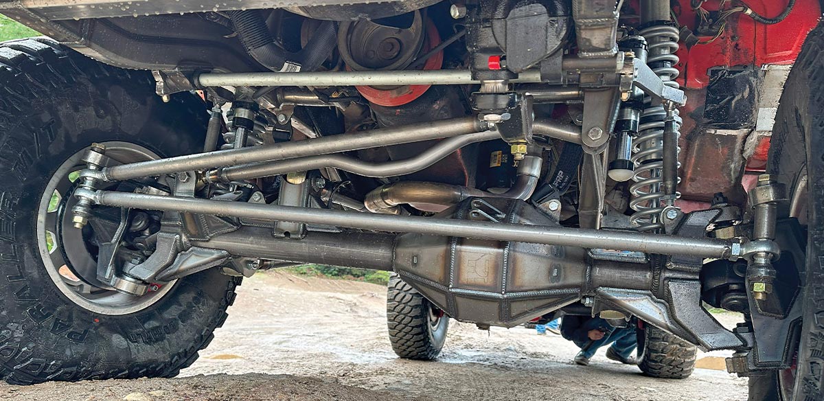 The complete 8-lug front suspension is as rugged as it is impressive looking. Note the dip in the Panhard rod for engine clearance.