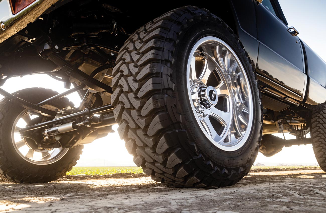 close low angle shot of the driver side front tire on the black Chevy K10