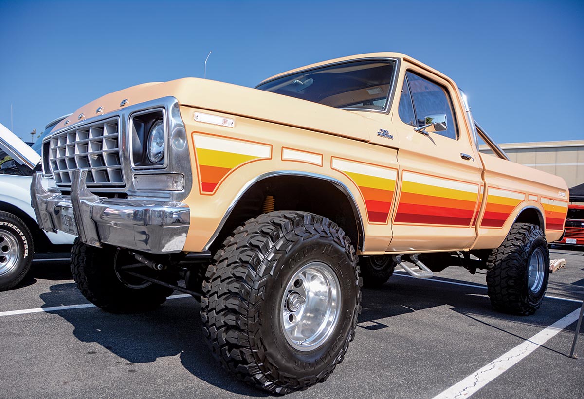 Close-up landscape photograph angle perspective of a cream-colored Ford vintage vehicle parked in a parking lot area next to another car