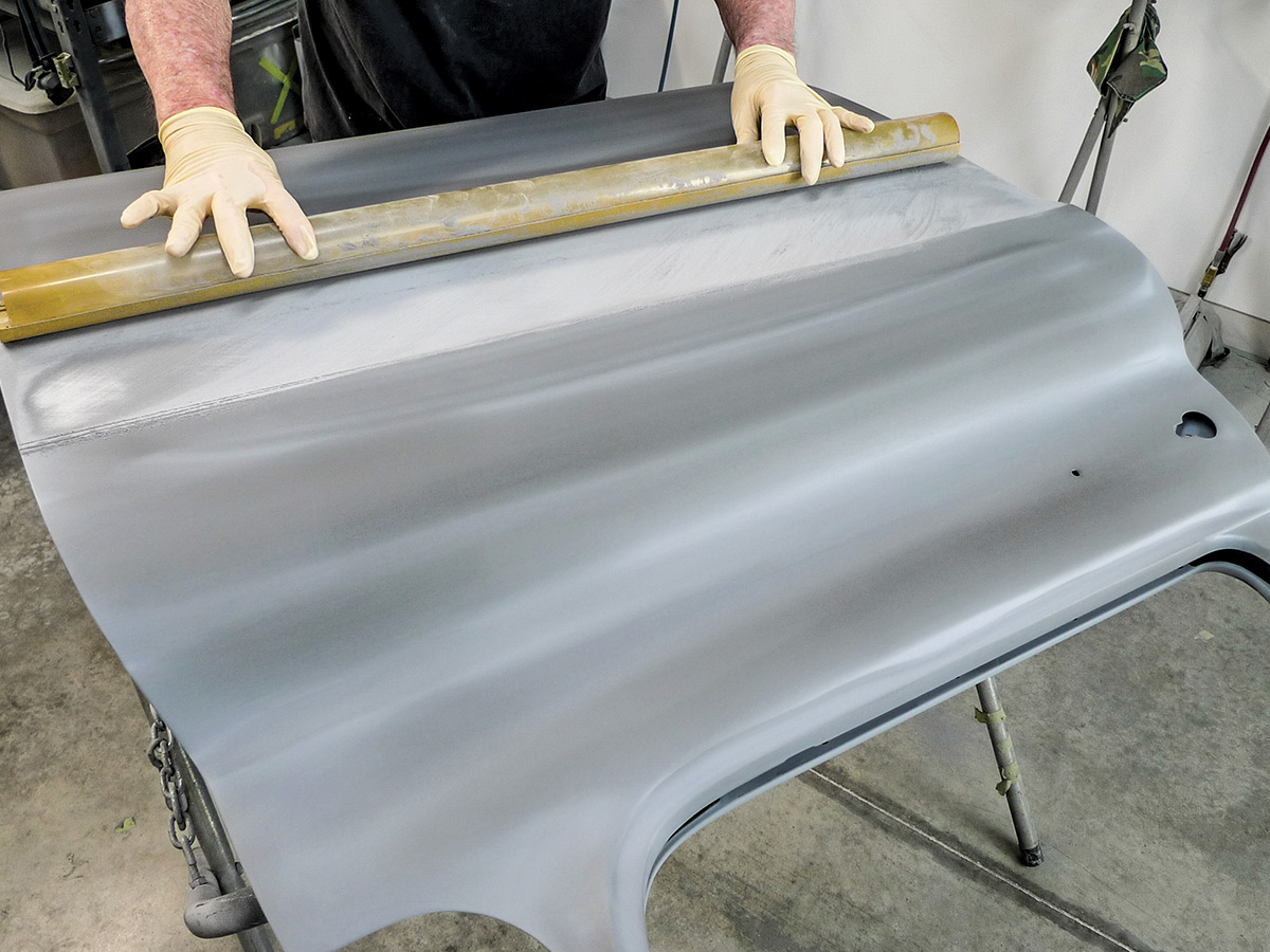 Hands using a fairing block on the exterior of the car door