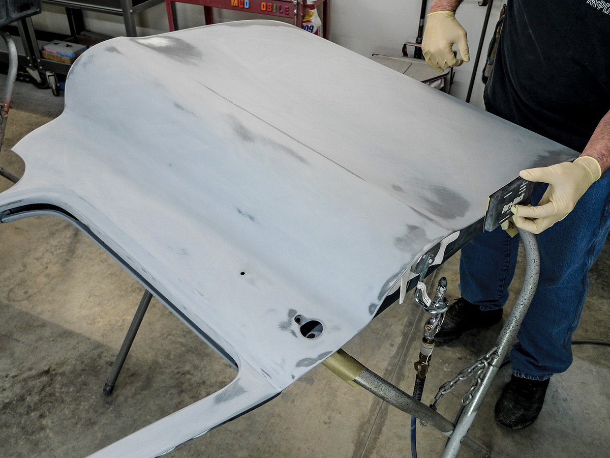 Hands using a fairing block on the edge of the car door