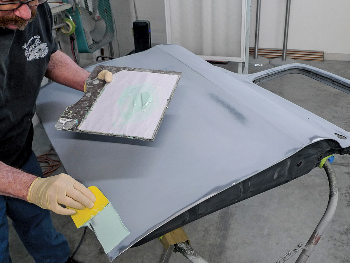 Man applying glazing to the unpainted car door