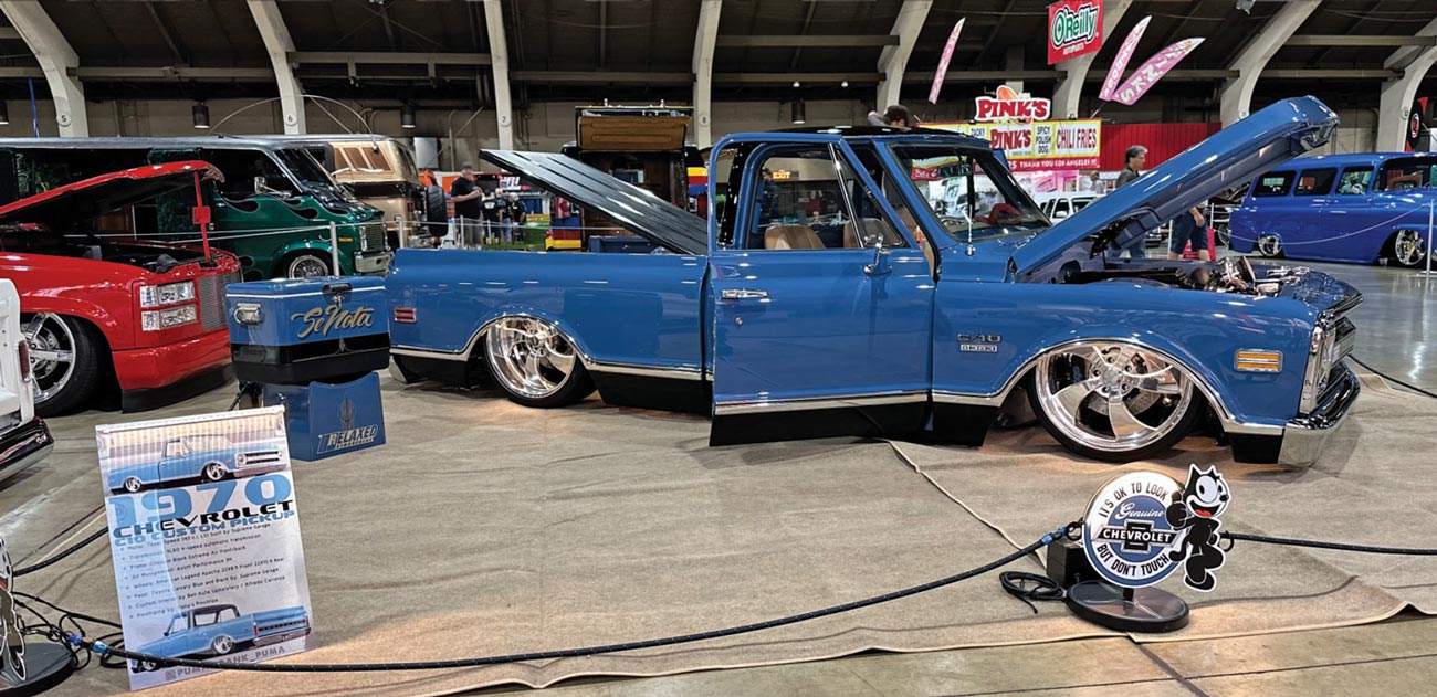 passenger profile of a sky blue 1970 Chevy C10 truck with its trunk hood, front hood and doors open