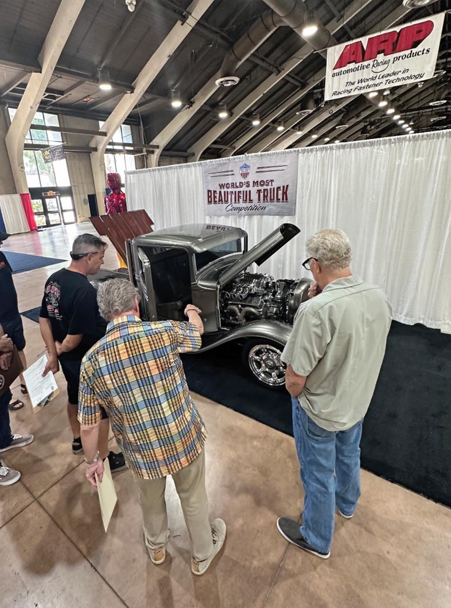 Inaugural O'Reilly Auto Parts Grand National Truck Show attendees admire a classic ford pick up with its hoods and doors open