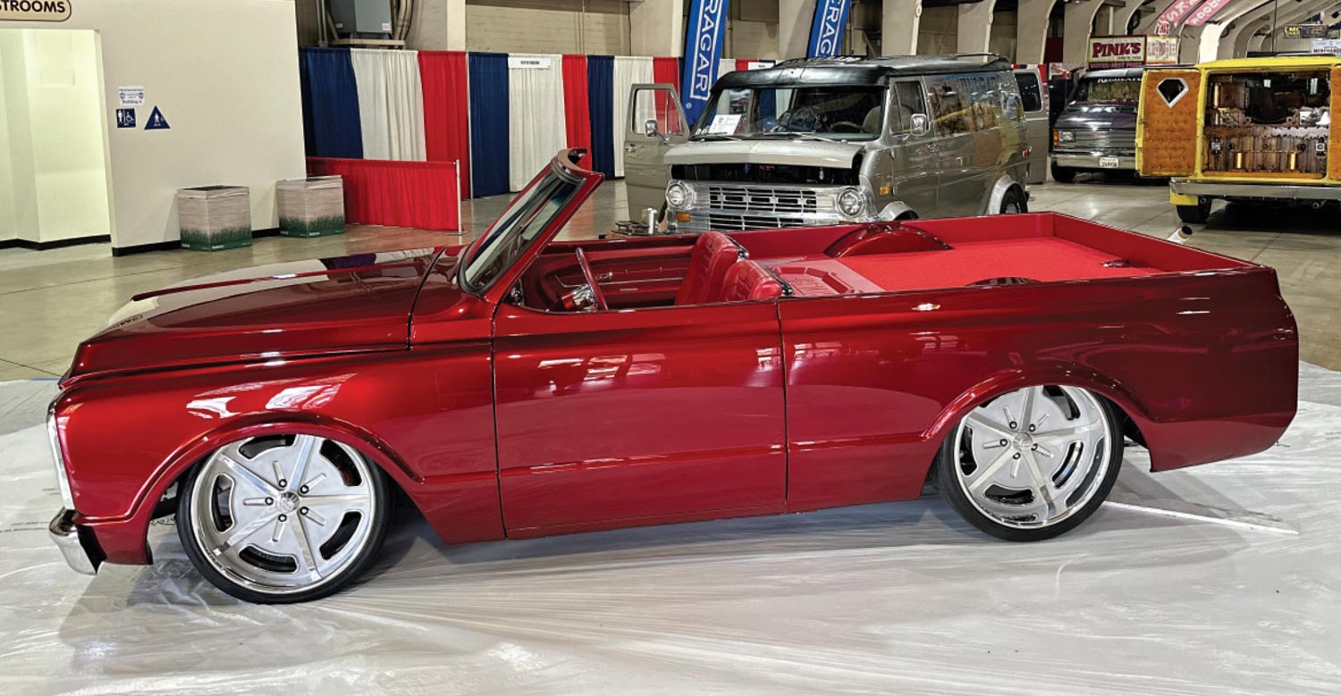 driver side view of a deep red topless classic truck