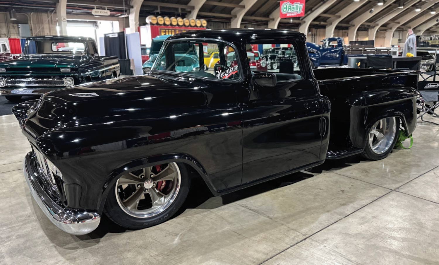 driver side quarter view of a glossy black classic truck