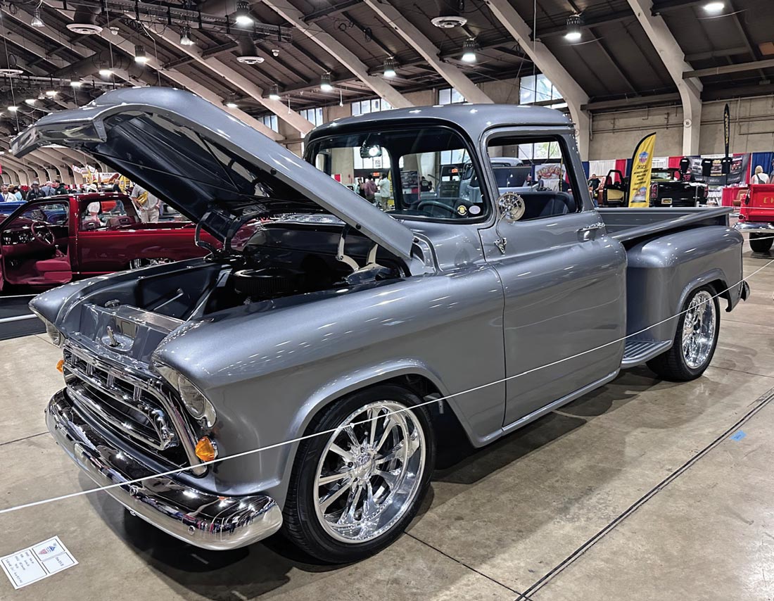 driver side quarter view of a metallic gray classic truck with its front hood open