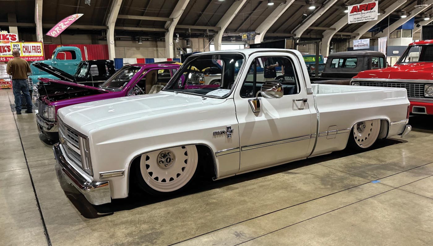 driver side quarter view of a white classic truck