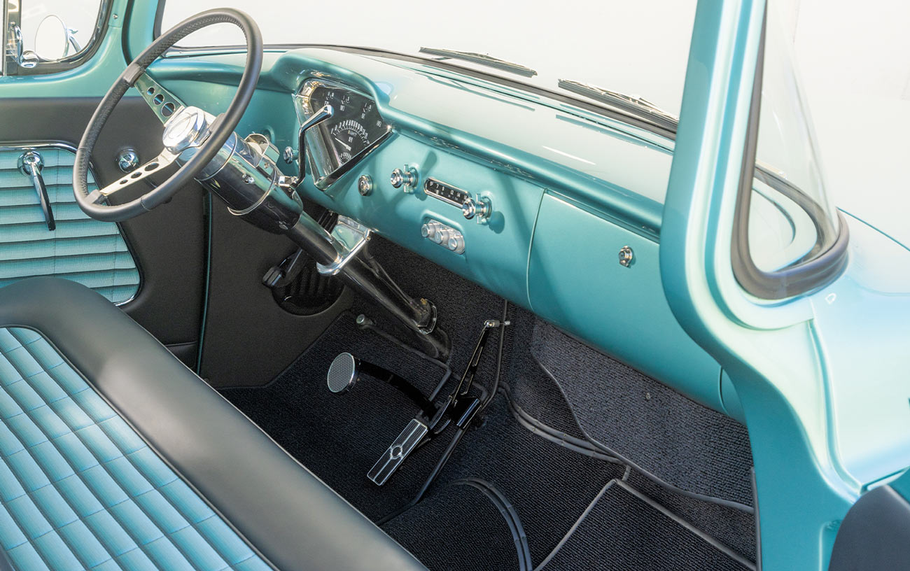 view from the open passenger side door inside the cab of the sea green ’56 Chevy truck, with a focus on the dashboard