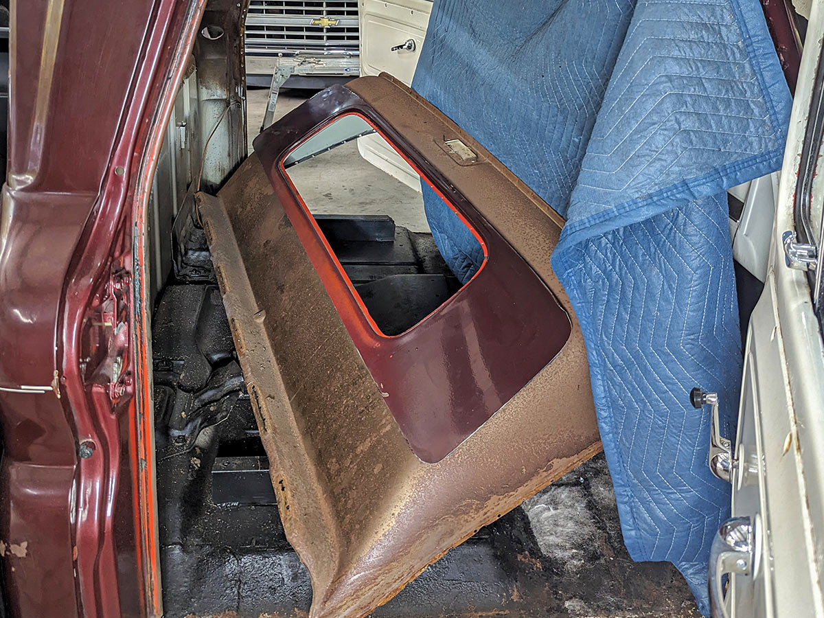 The old back panel laying inside the truck cab