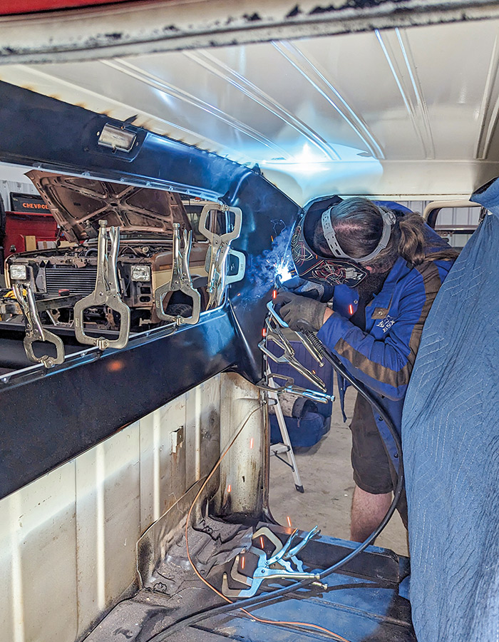 Man welding the panels inside the cab of the truck