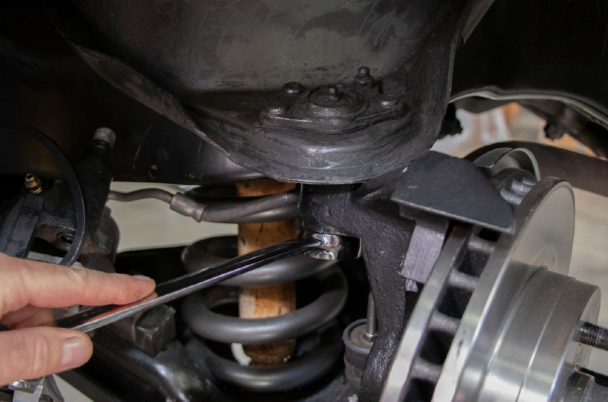 After removing the cotter pins and retaining nuts the big hammer was once again used to remove the spindles from the upper ball joints. An alternative is a pickle fork or a tie rod/ball joint separator. 