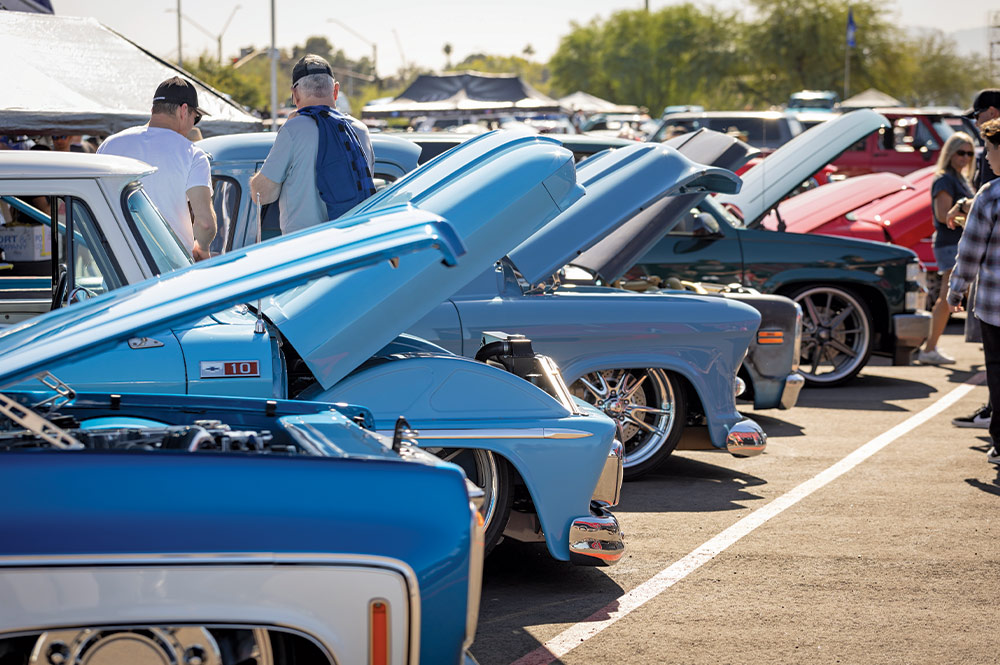 blue classic trucks lined up with hoods open