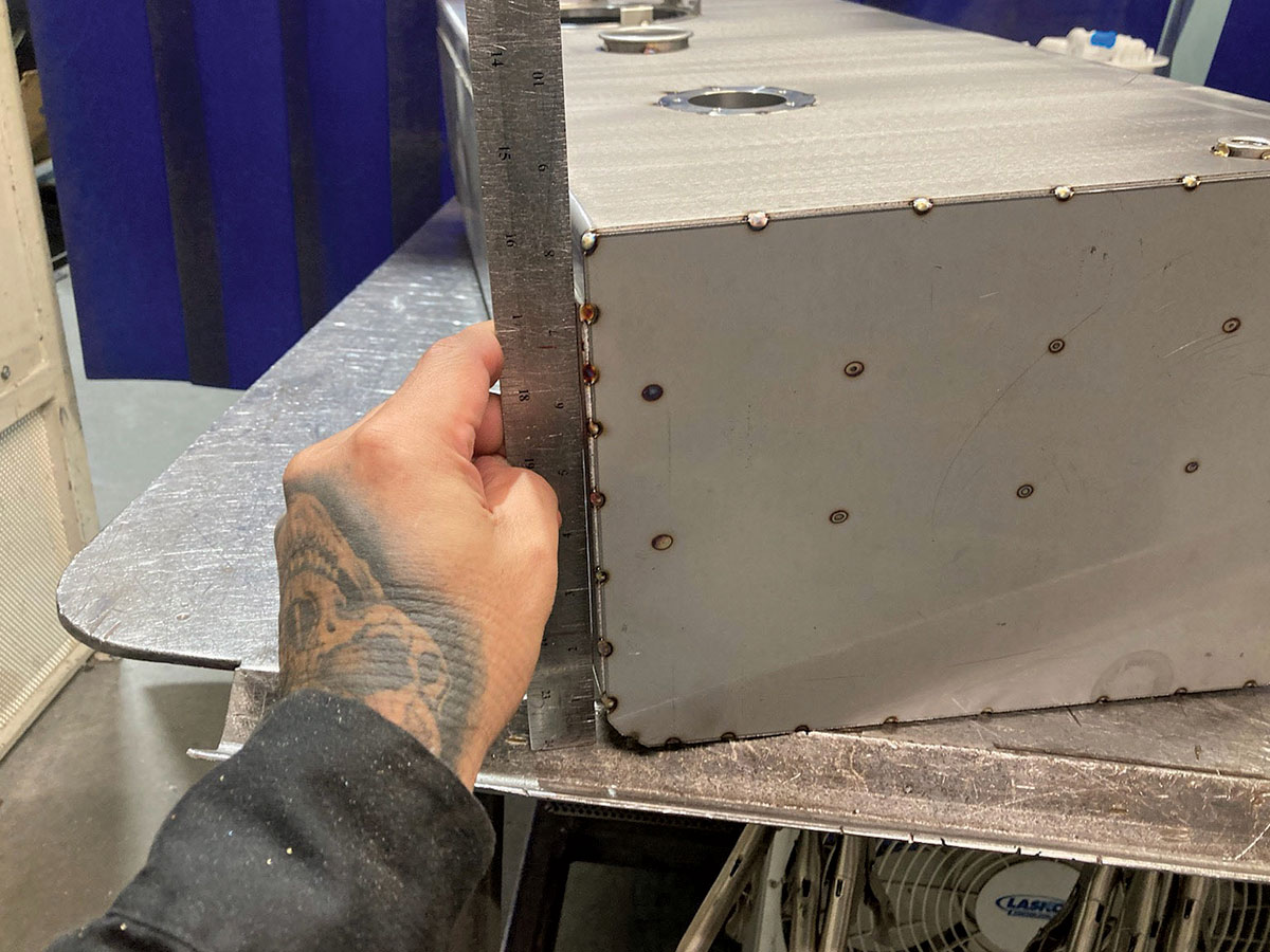 With the top, bottom, and internals of the tank all in place, the side panels are laser cut and also tacked into position.