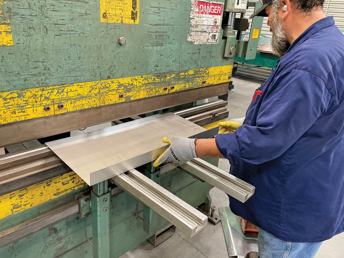 The process starts with a fresh piece of 14-gauge, 308 stainless steel cut to length then formed in one of two press/brakes. This piece will form the top of the tank.
