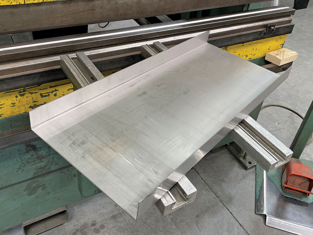 The process starts with a fresh piece of 14-gauge, 308 stainless steel cut to length then formed in one of two press/brakes. This piece will form the top of the tank.