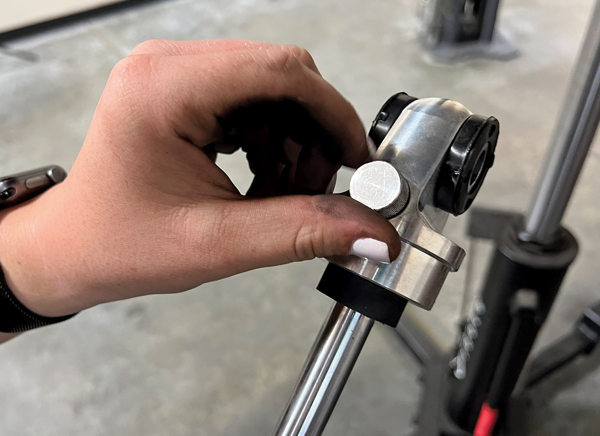 close view of fingers adjusting the rear rebound setting on the Aldan American smooth body shock absorbers