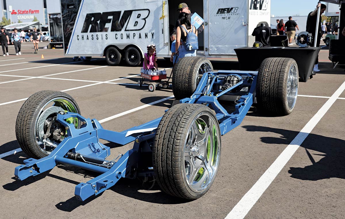 Close-up landscape photograph view of a blue colored Chevrolet tilt axis vintage car part that connects all four wheels together parked in a parking lot space