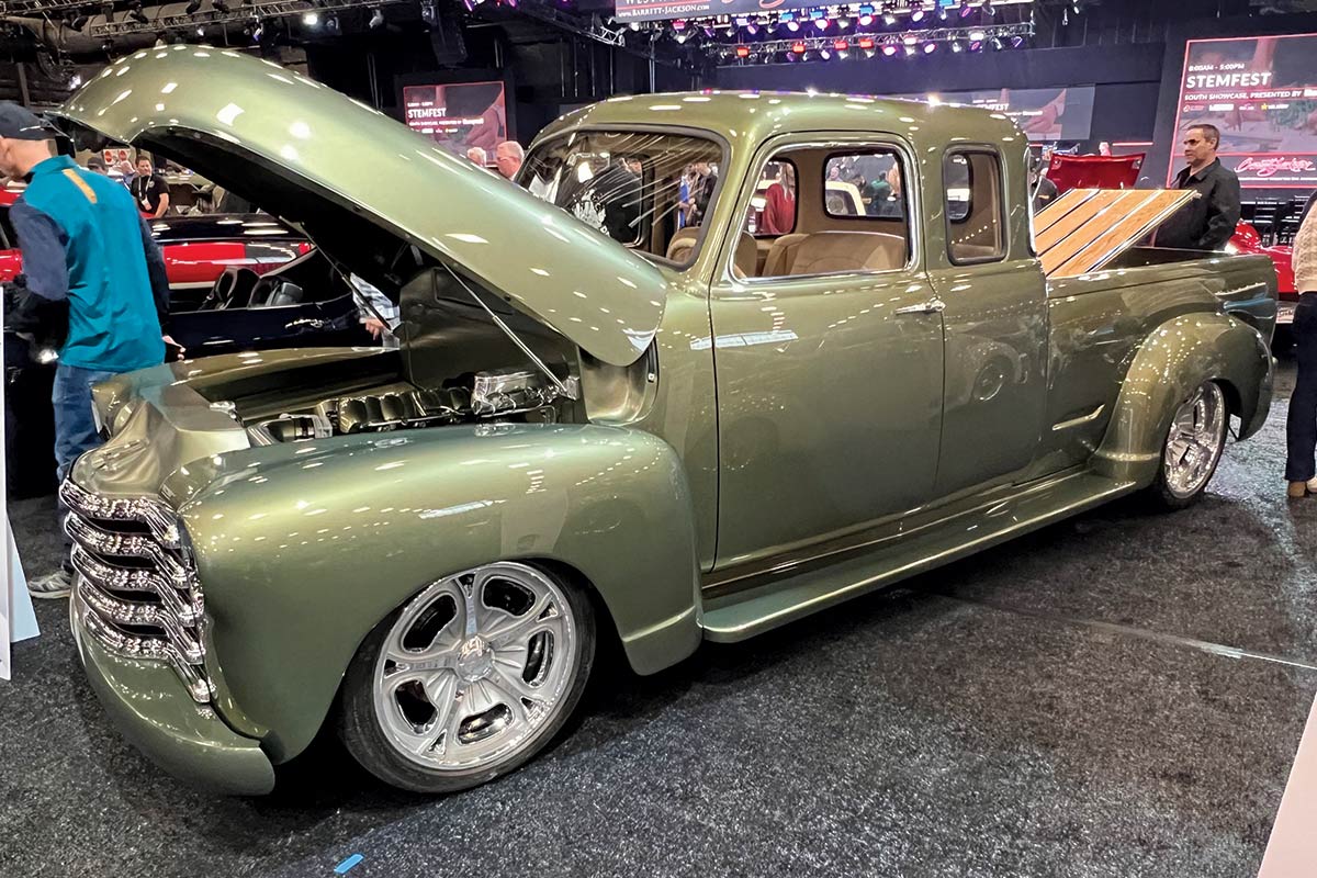 3/4 side view of olive green pickup truck with hood and trunk open
