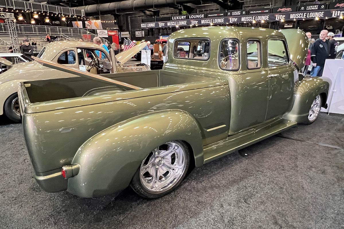 rear view of olive green pickup truck with hood and trunk open