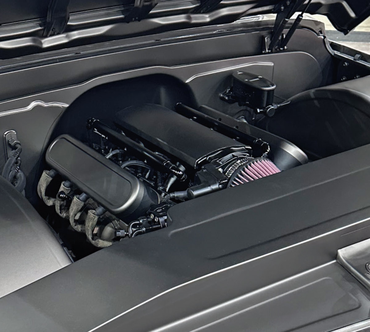 close up of the the two toned grey, low riding chevy truck's engine