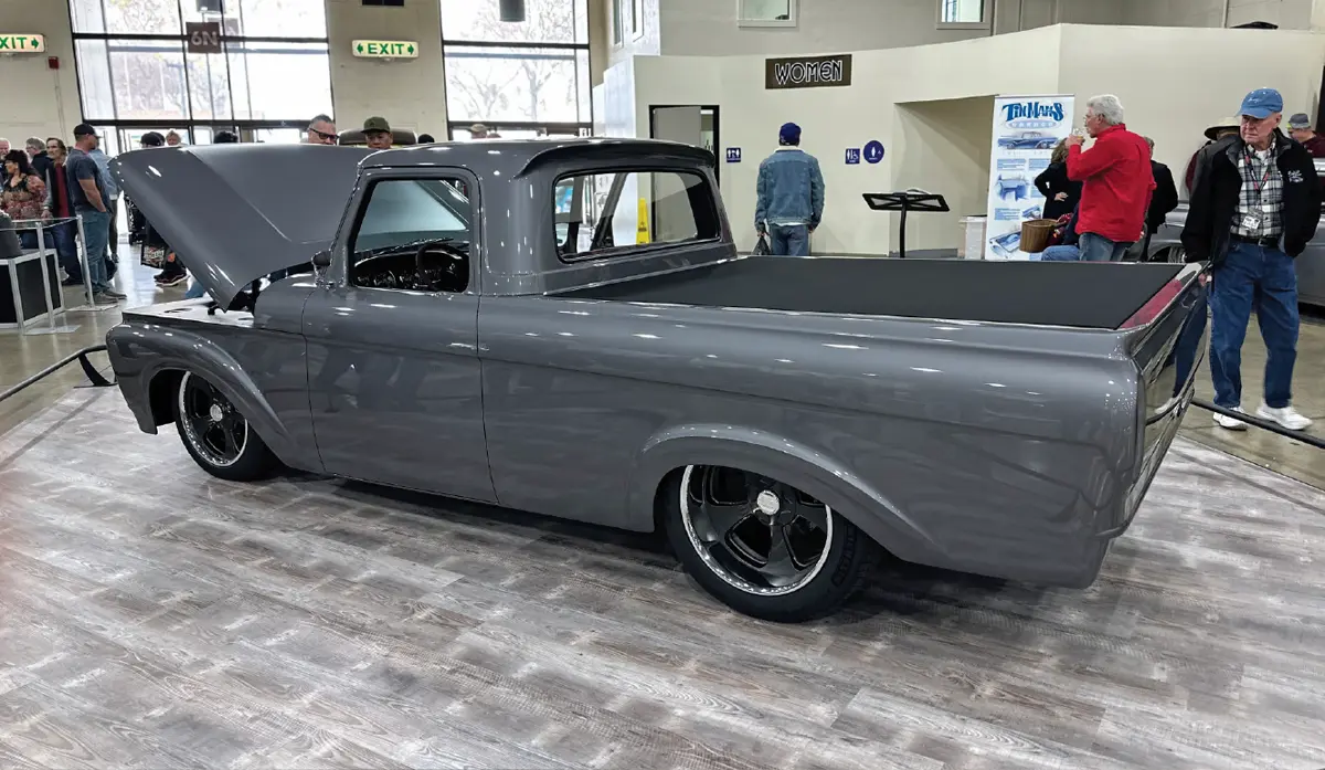 quarter rear driver side of the dark grey classic truck with its hood open