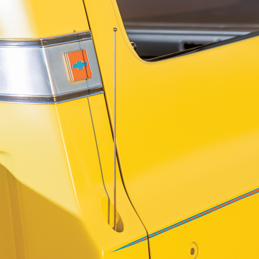 closeup of chevy logo on yellow ’74 Stepside Squarebody pickup truck