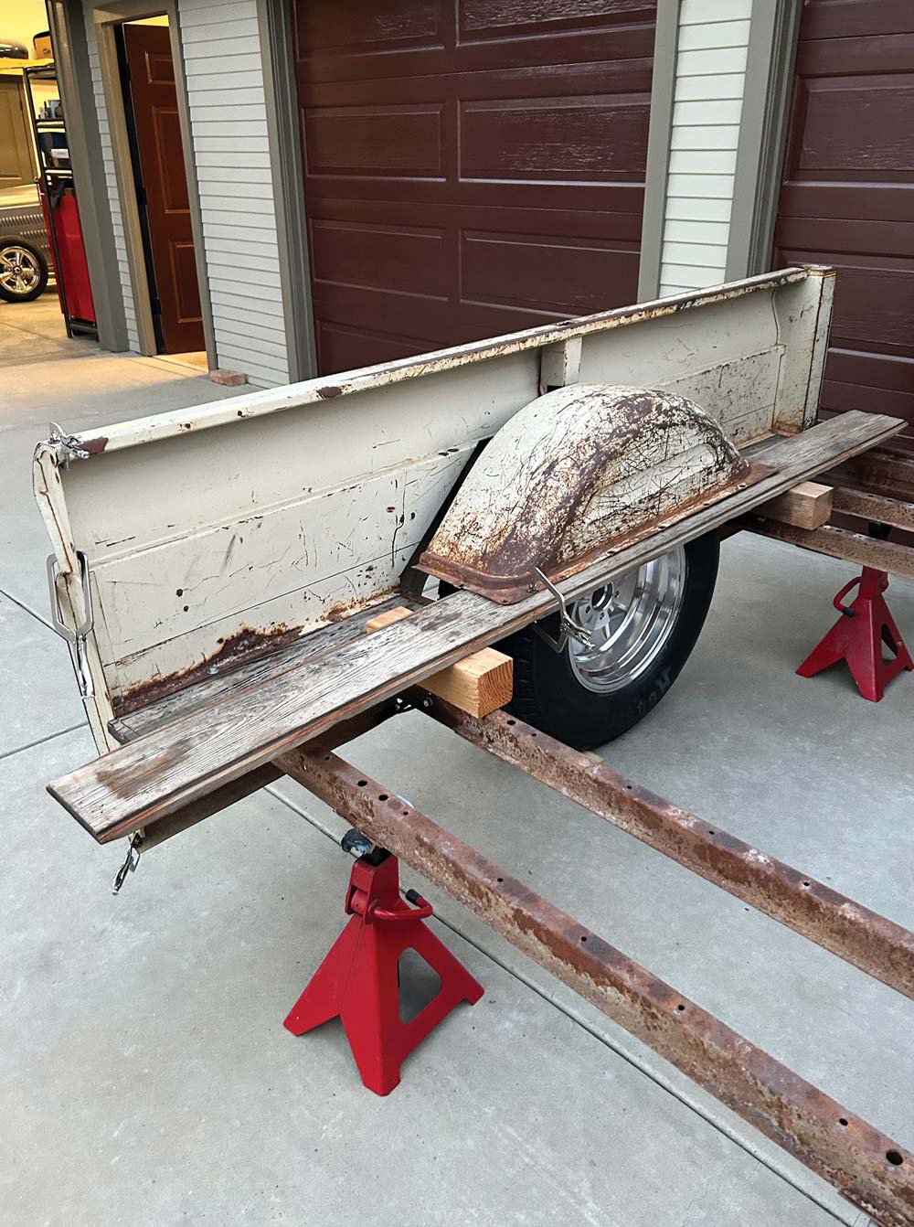 piece of a bed of truck being supported by pieces of wood