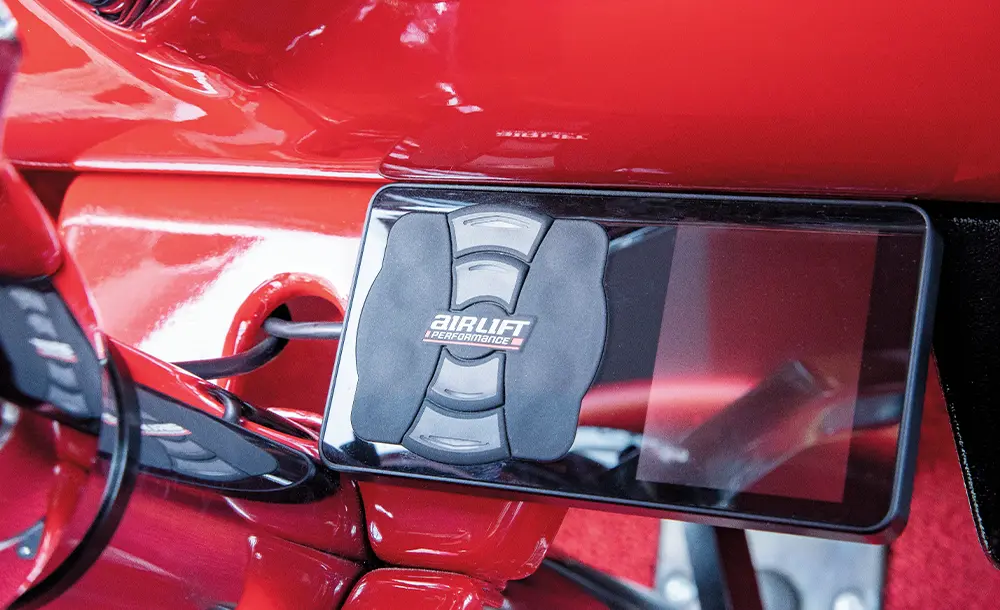 close view of the Air Lift Performance 3P ride height control panel on the dashboard, at the base of the steering wheel