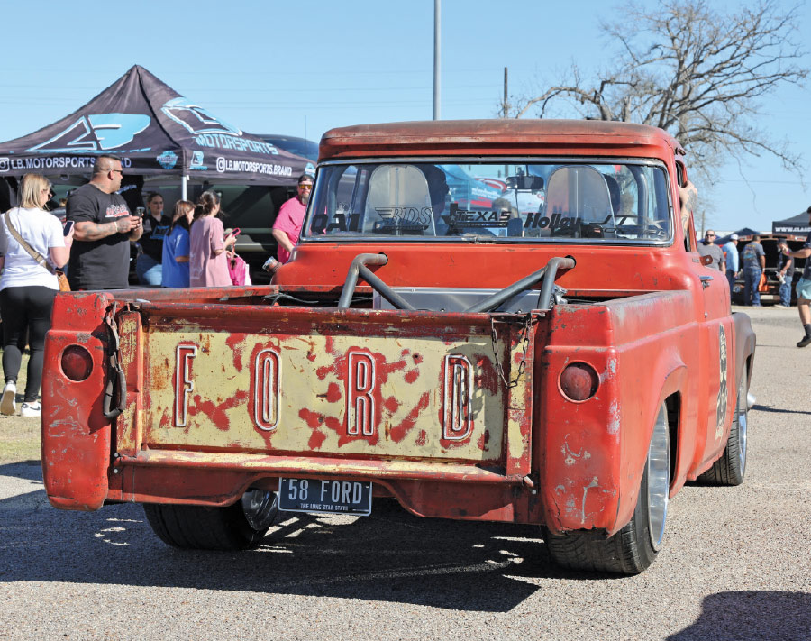 rear view of red rusty truck with large ford logo on the trunk door