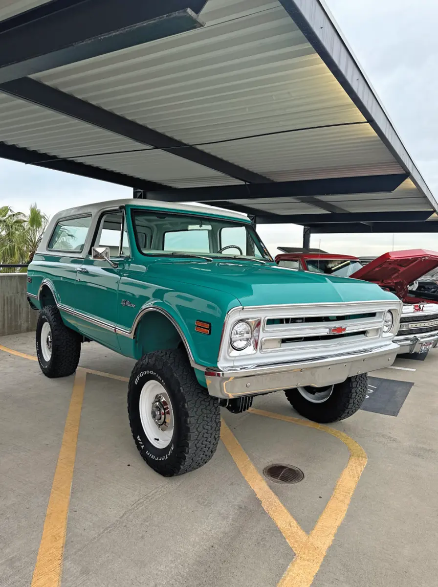 passenger side quarter view of a sea green classic Chevy Blazer with all terrain tires