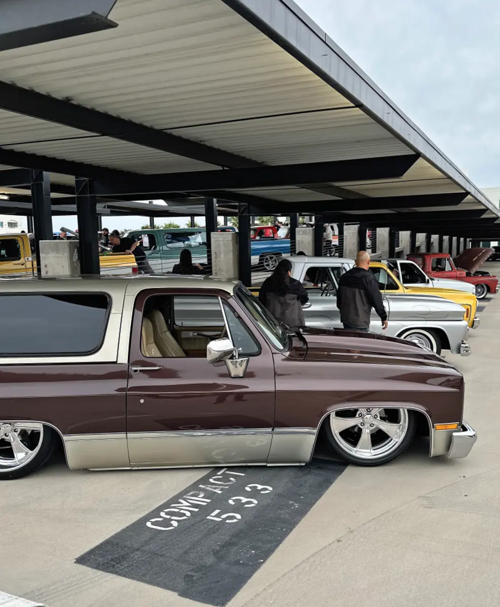 cropped passenger side view of a retro dark brown and pale bronze lowriding Blazer