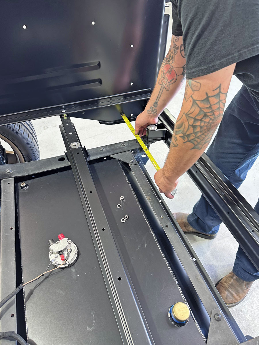 man measuring chassis with yellow tape